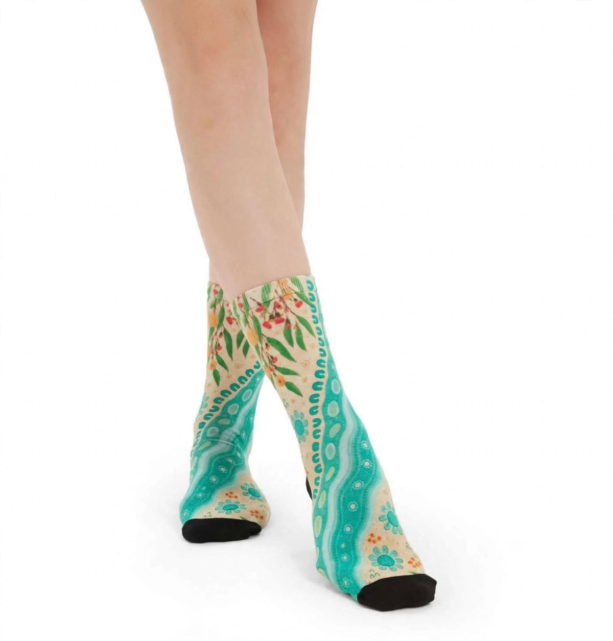 Waterways by Caitlin Trindall: aqua and cream bamboo socks with flowing patterns and botanical details worn on feet.