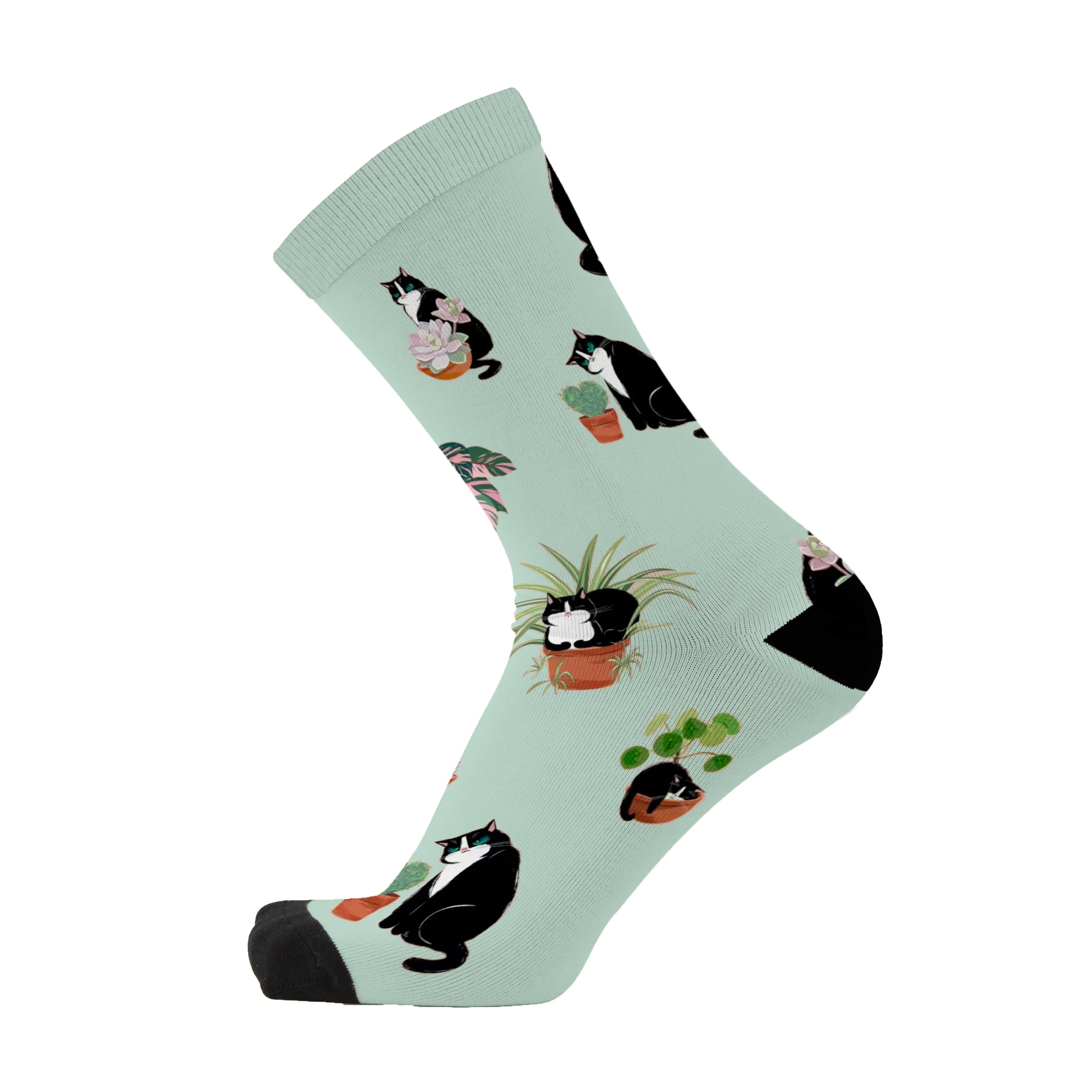 Colourful bamboo socks featuring cats and plants on a light green background.