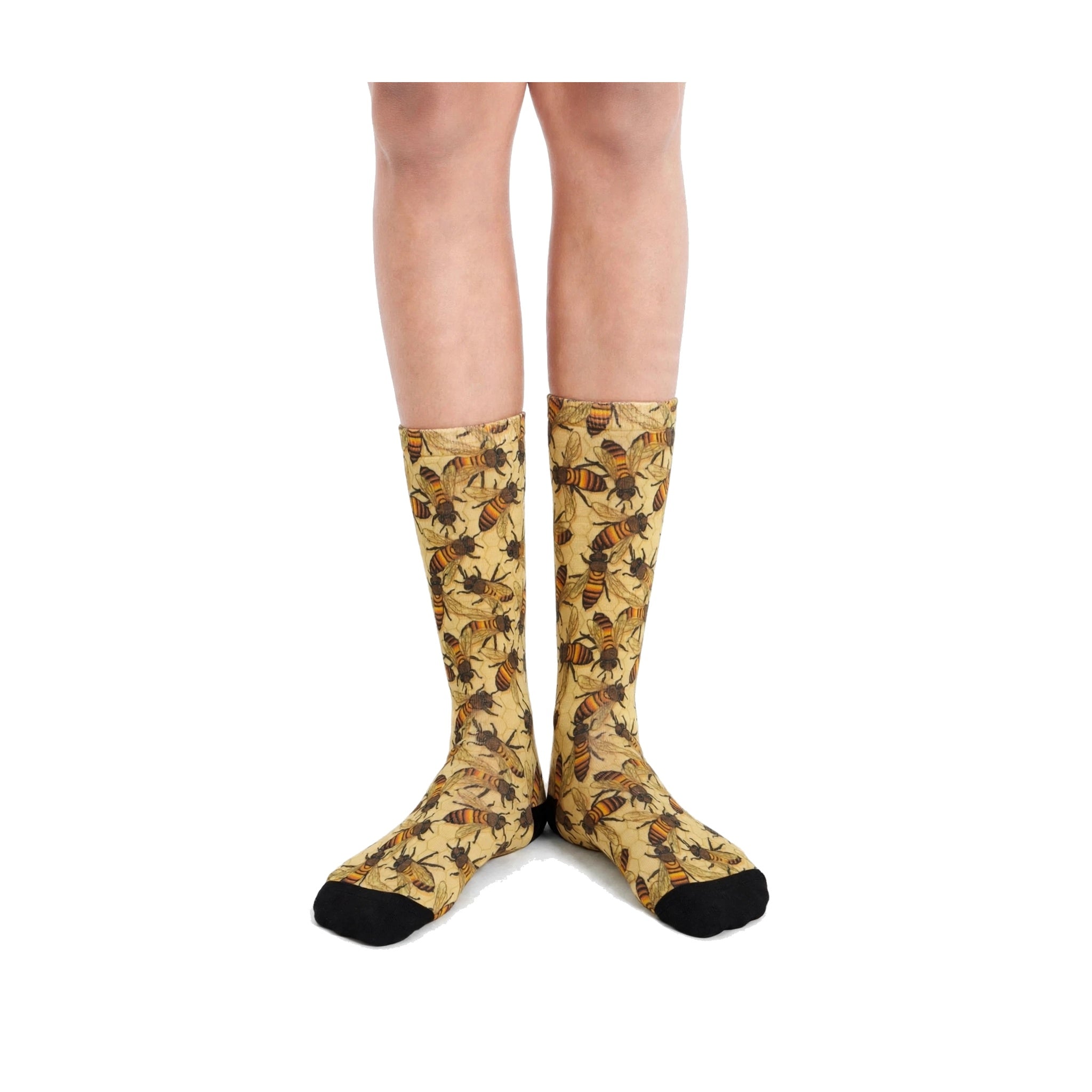 A pair of knee-high socks with a detailed floral and bee pattern in yellow, brown, and black, worn on a model's legs against a plain white background.