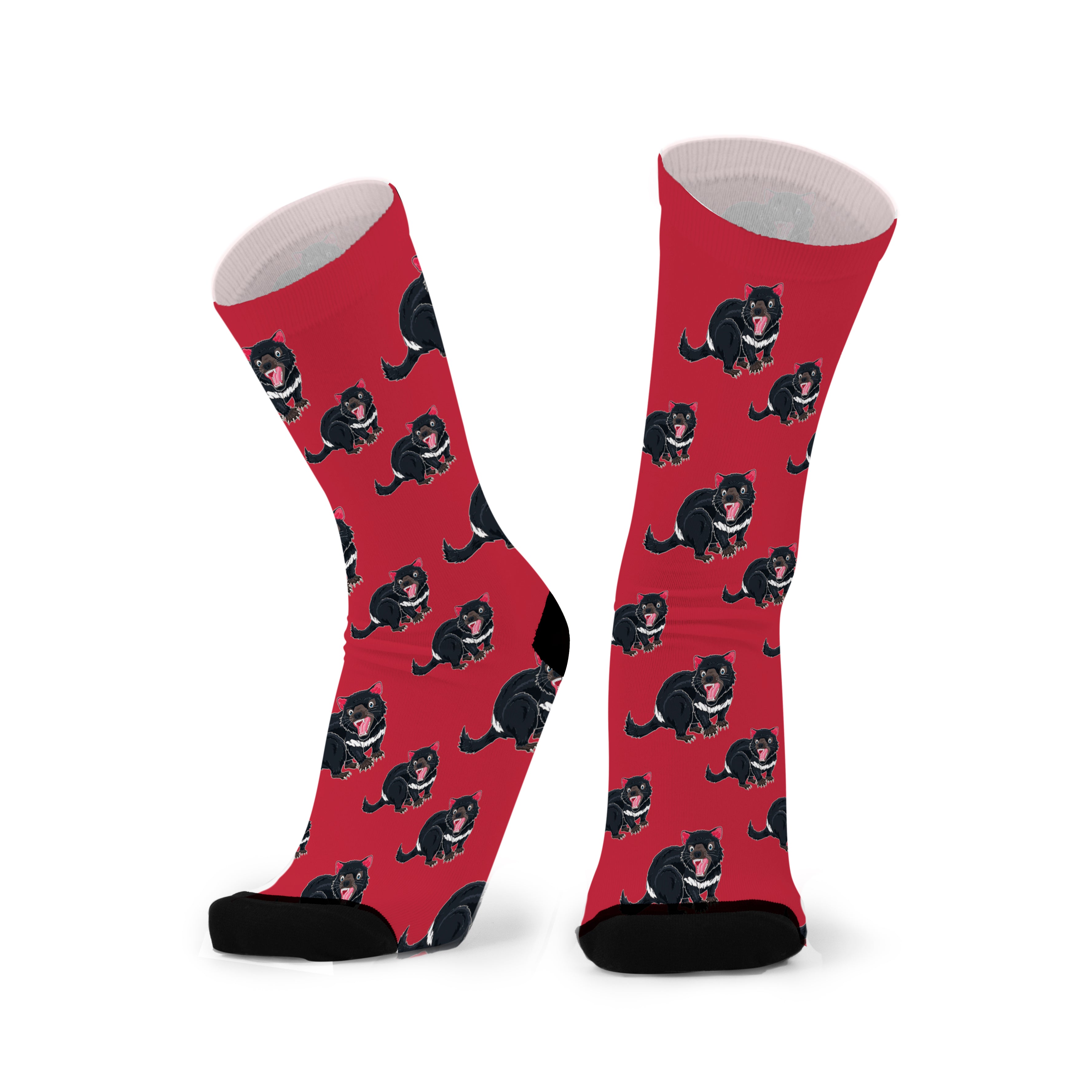 A pair of red socks with a pattern of black Tasmanian devils, featuring a seamless design with reinforced toe and heel areas.