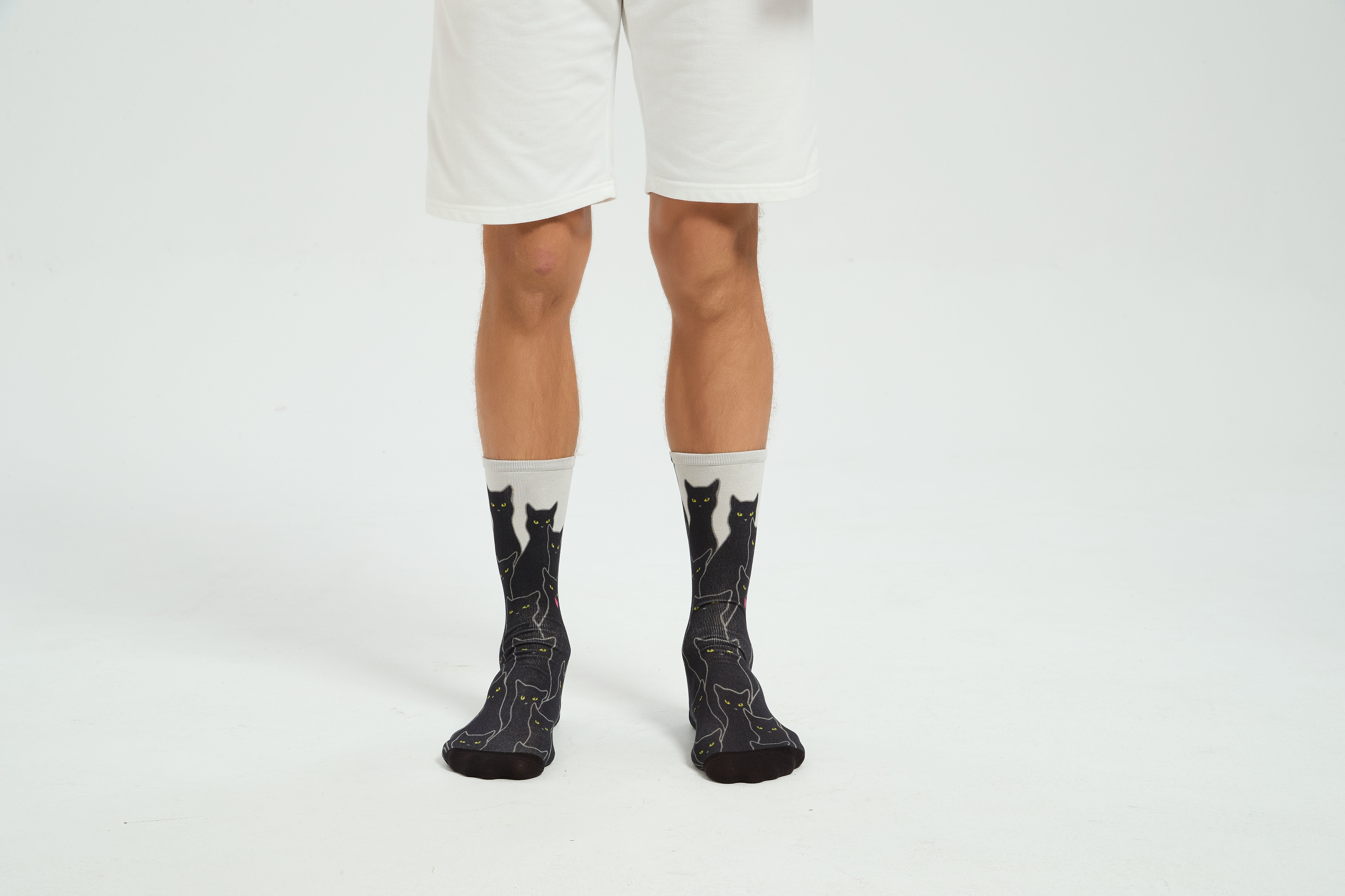 Colourful bamboo socks featuring black cats on a white background.
