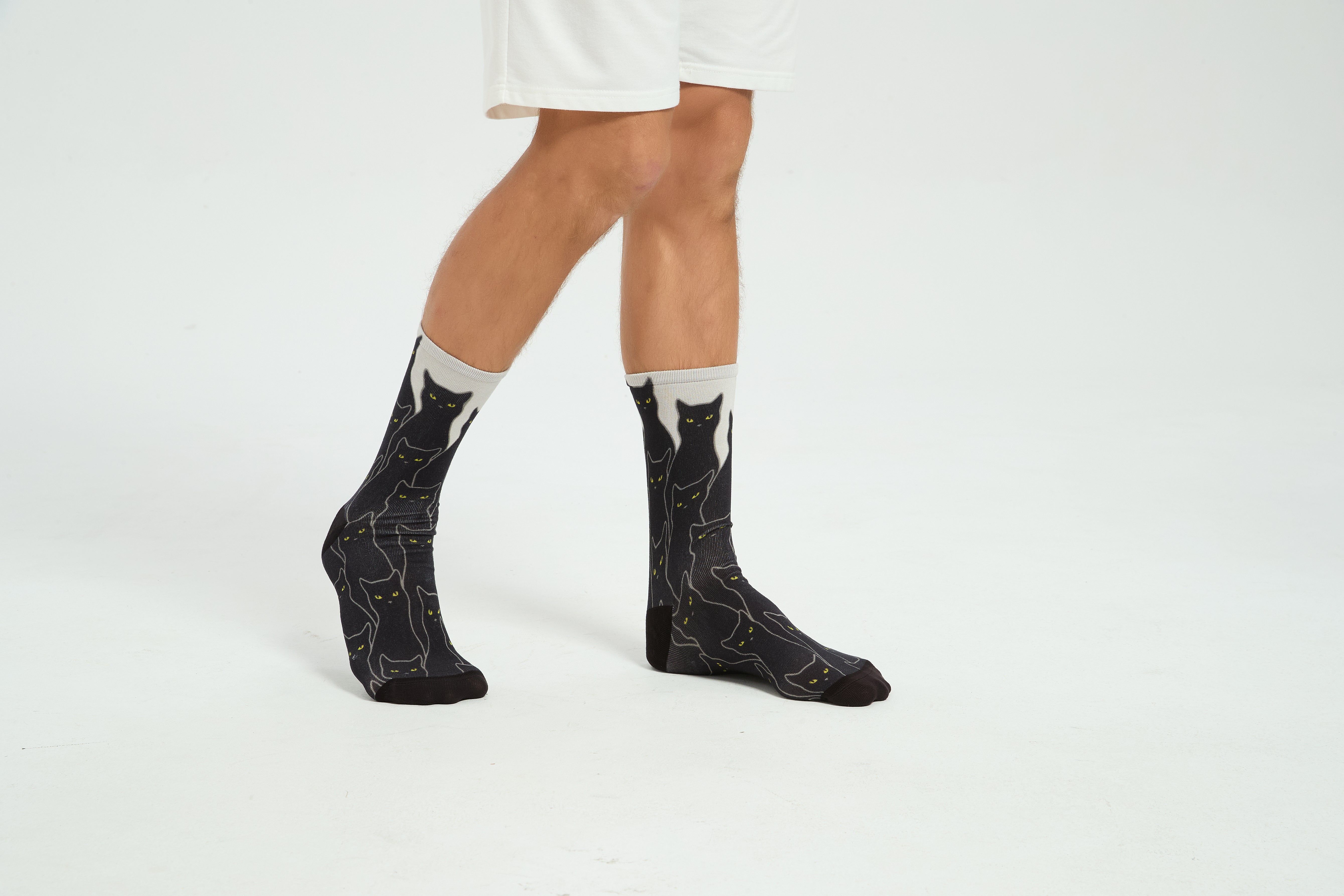 Colourful bamboo socks featuring black cats on a white background.