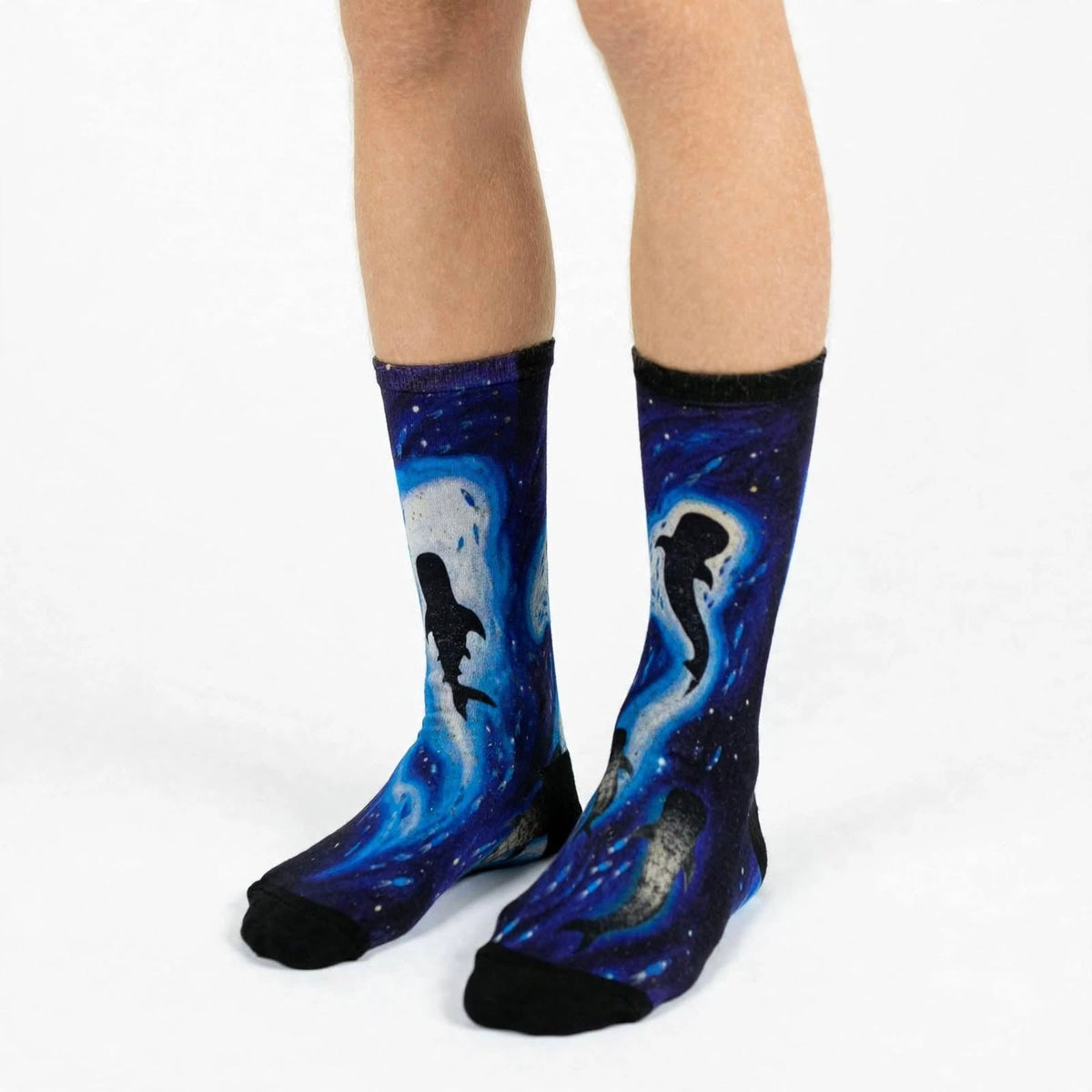 Giants of the Blue by Melanie Hava: navy whale-print bamboo socks worn on feet.