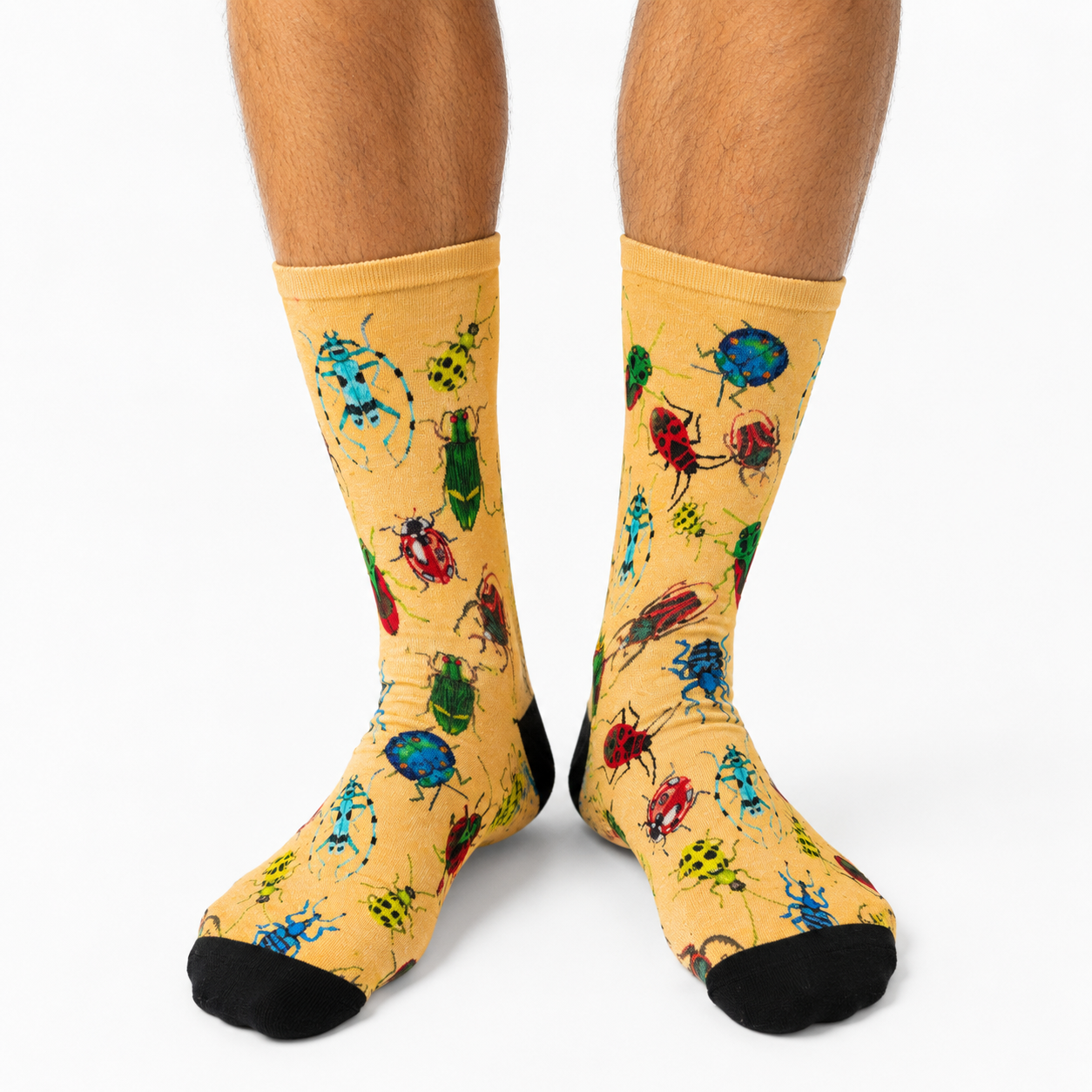 Yellow socks with beetle pattern worn by a person on a white background