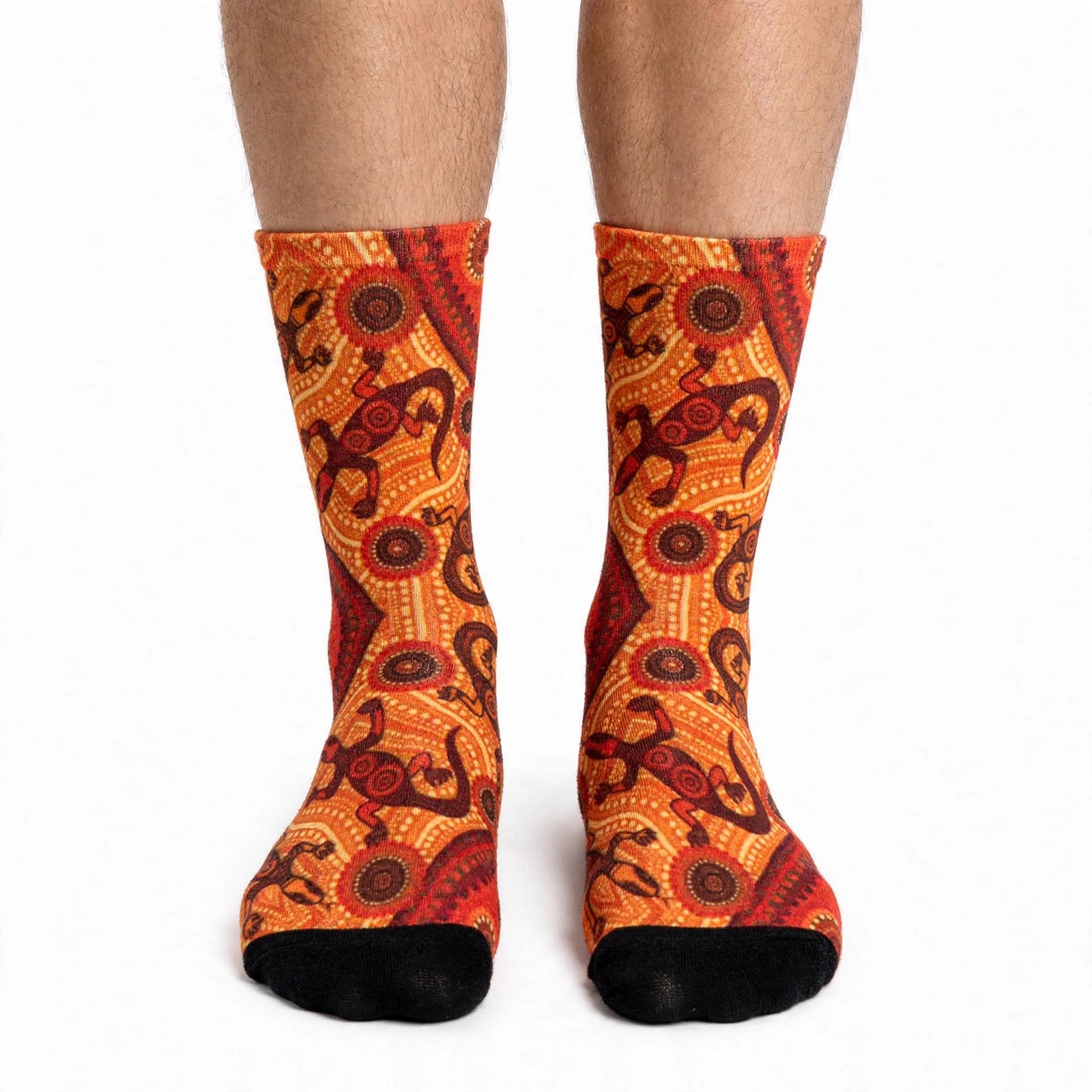 A pair of patterned socks featuring sand goannas (biiwii) in beige, brown, and black colors, designed by Kirsten Gray.