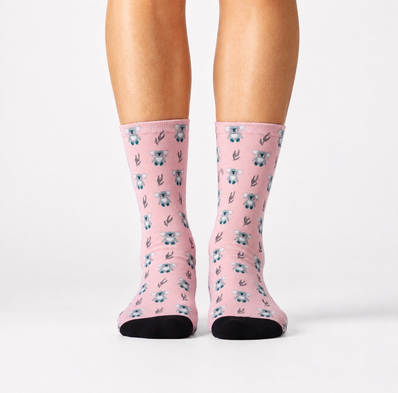 Pink socks with floral pattern worn by a person on a white background