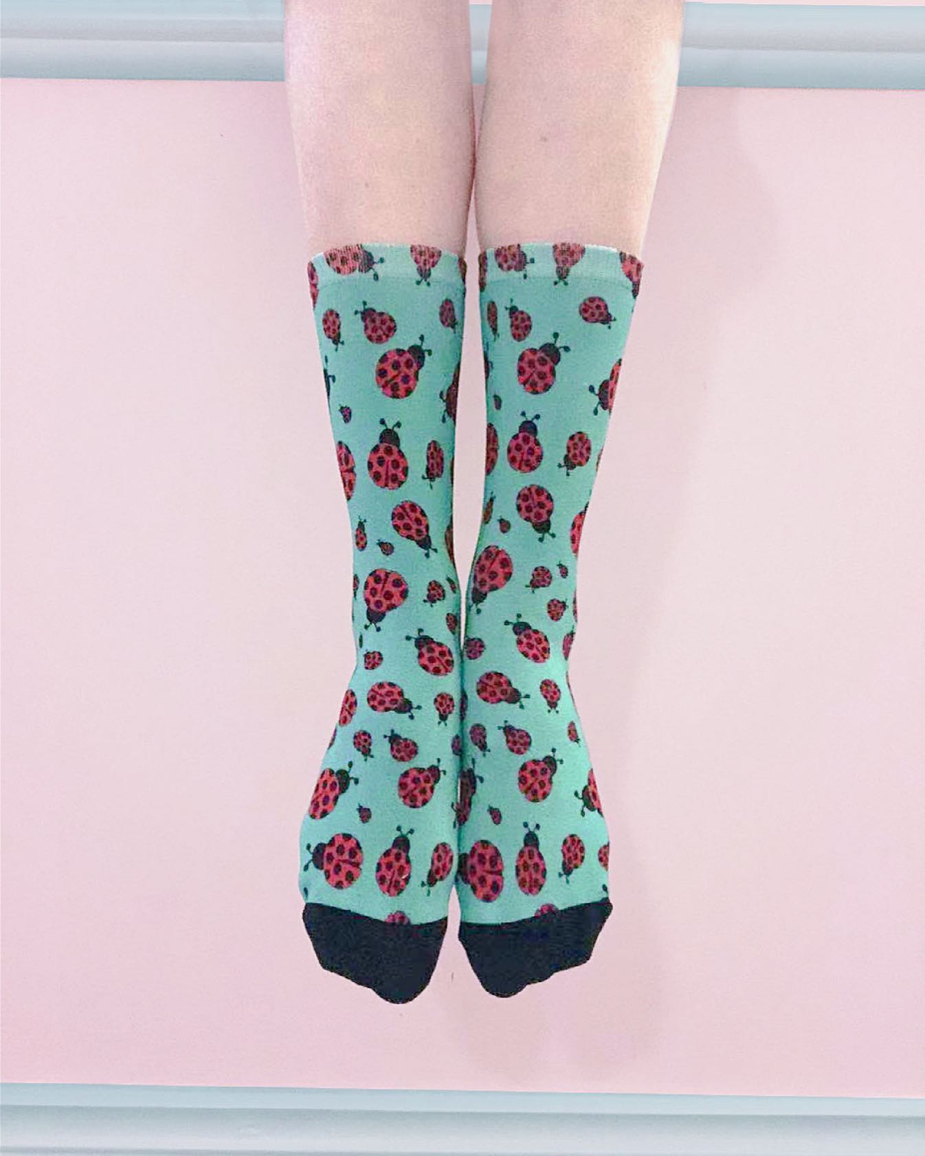 Colourful bamboo ladybug socks with red ladybugs on a turquoise background, soft comfortable crew socks perfect for gifts and everyday wear.
